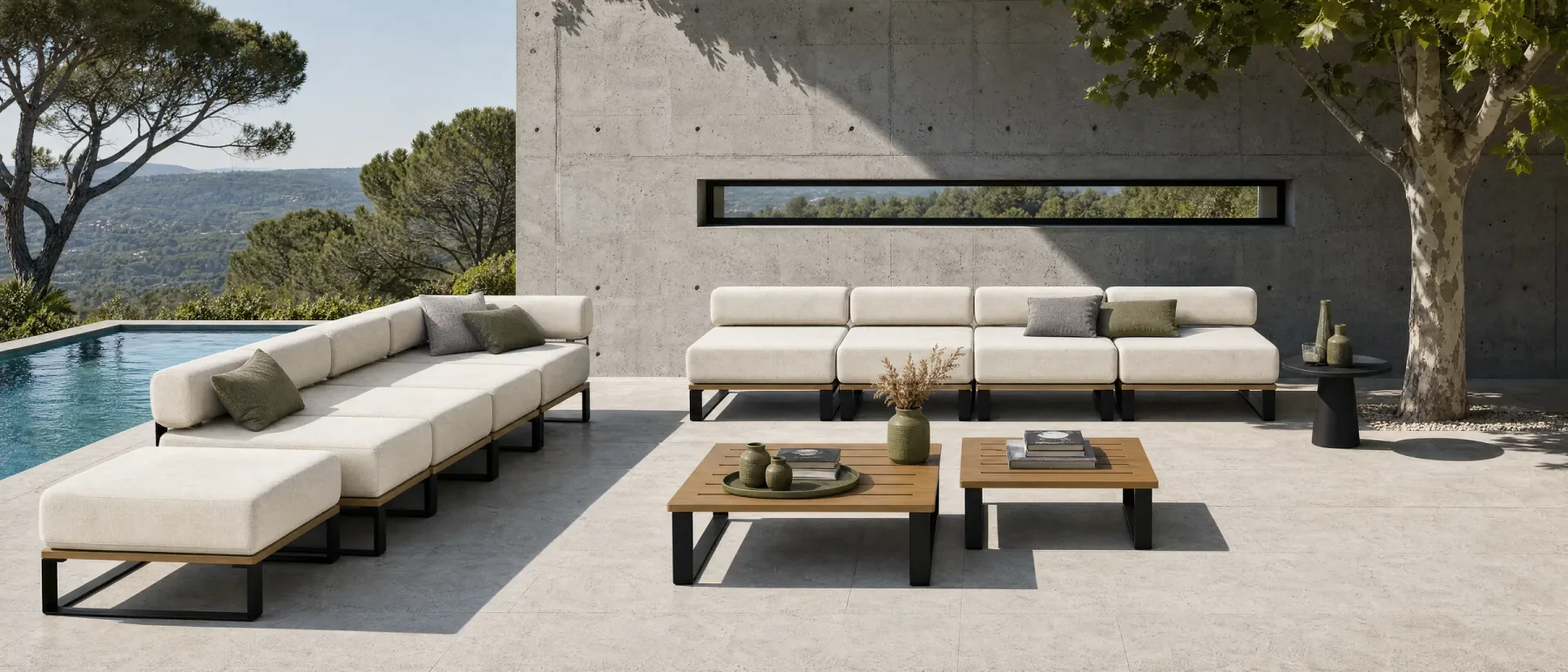 A Nour arrangement beside a pool at a villa: a long run facing the water with two low tables in front of it and a chaise at the near end, the black frames reading as thin lines against the paving.