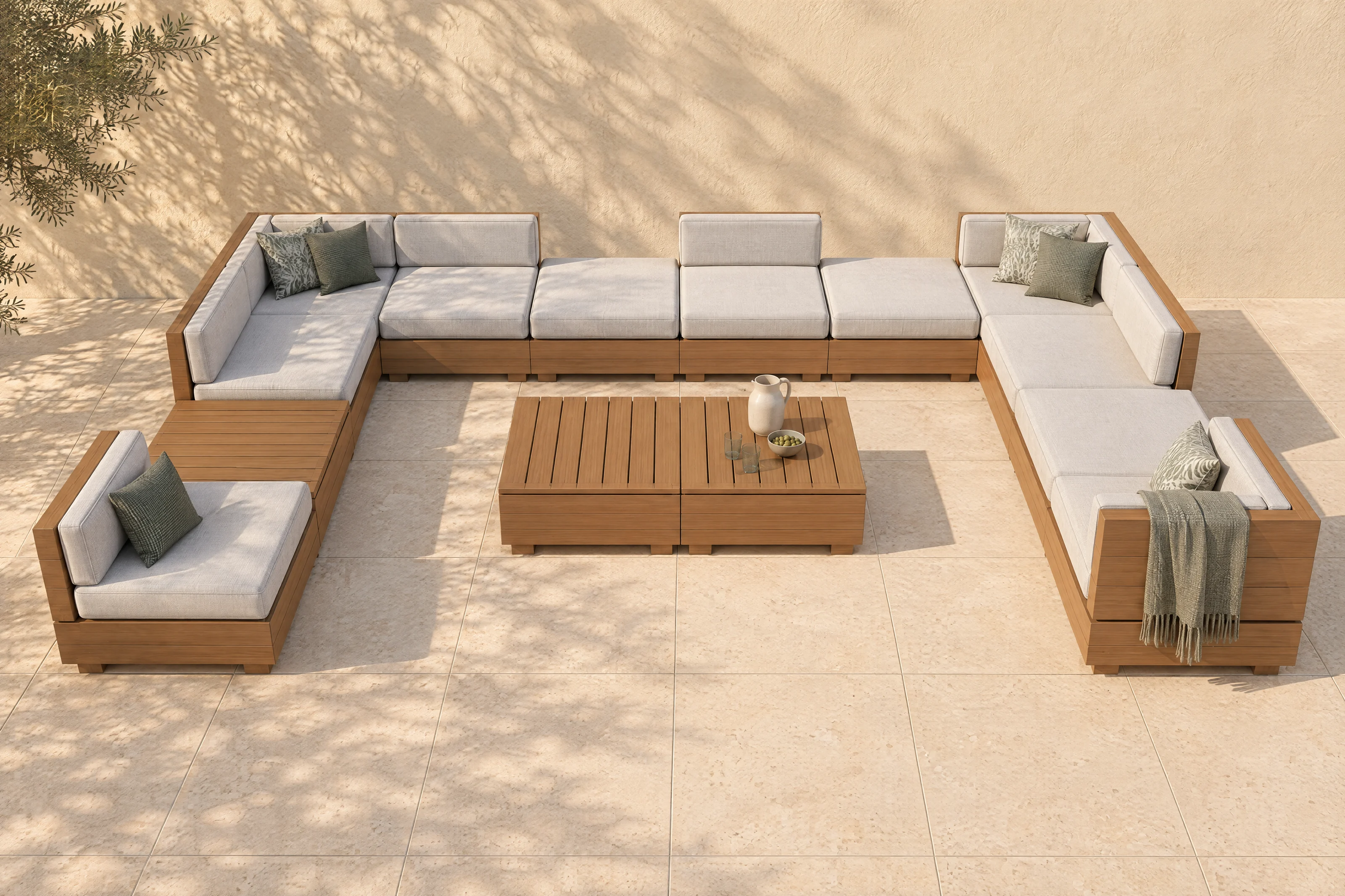 A Sama arrangement in the founder's own U on a limestone terrace, off-white cloth on honey timber, no one in it, the shadow of an olive tree on the warm plaster wall.