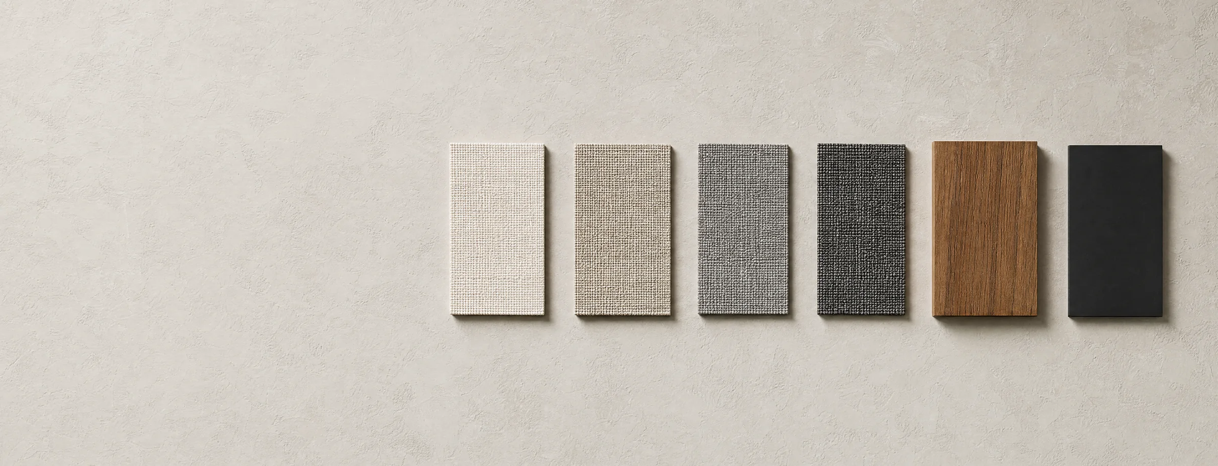Six material samples laid in a row across the right of a pale limewashed plaster surface: four outdoor weaves running from warm off-white through oatmeal and grey to charcoal, an offcut of oiled teak timber, and a flat chip of matte black powder-coated metal.